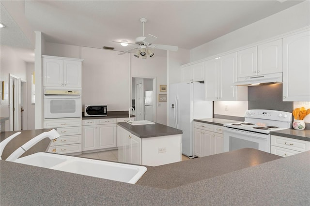 kitchen featuring a kitchen island, white appliances, and white cabinets