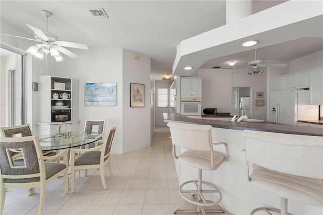 kitchen with ceiling fan, white cabinetry, white appliances, and kitchen peninsula