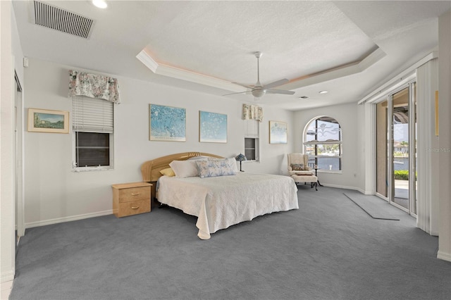 carpeted bedroom featuring access to exterior, a raised ceiling, a textured ceiling, and ceiling fan