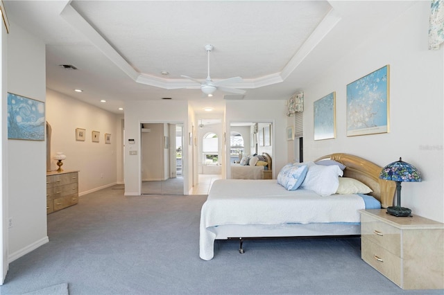 carpeted bedroom with ceiling fan, crown molding, and a tray ceiling