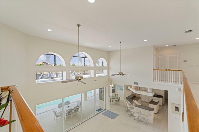 interior space with a high ceiling and ceiling fan