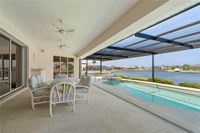 view of pool featuring a water view, a patio, ceiling fan, and a lanai