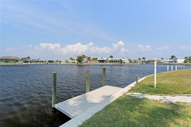 dock area with a water view and a yard