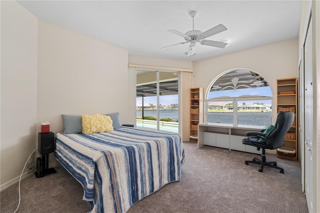 bedroom with ceiling fan, a water view, and carpet floors