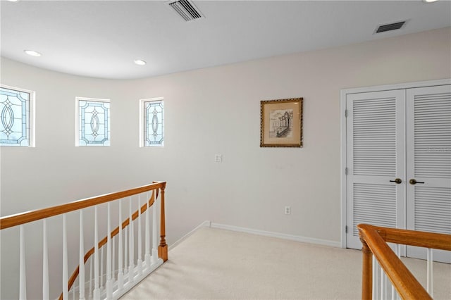 hallway with light colored carpet