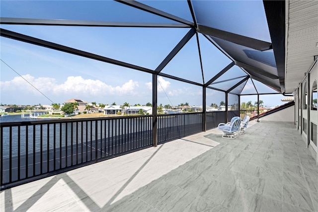 view of patio / terrace with glass enclosure and a water view