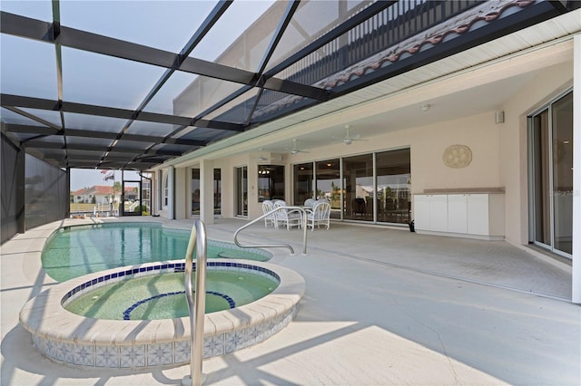 view of pool featuring glass enclosure, an in ground hot tub, and a patio