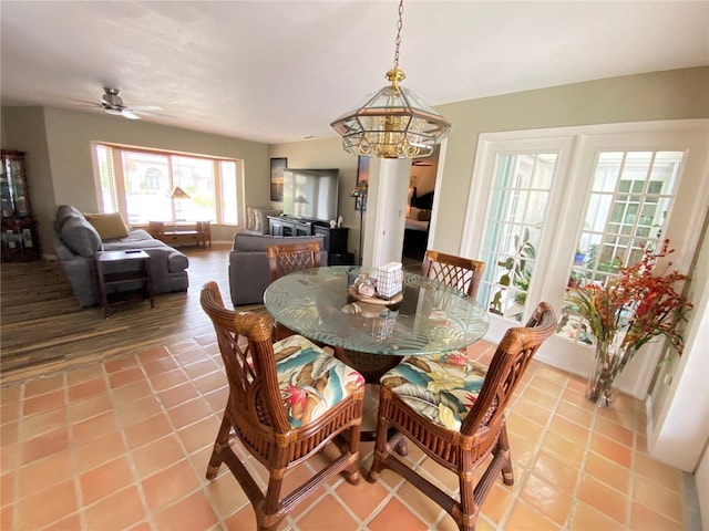 dining area featuring light tile floors and ceiling fan with notable chandelier