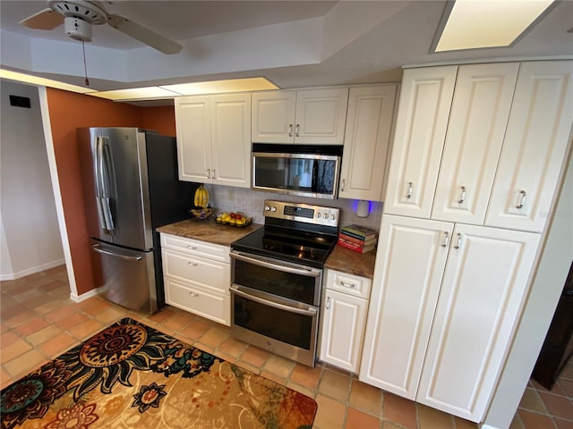 kitchen featuring ceiling fan, tasteful backsplash, white cabinets, light tile floors, and appliances with stainless steel finishes