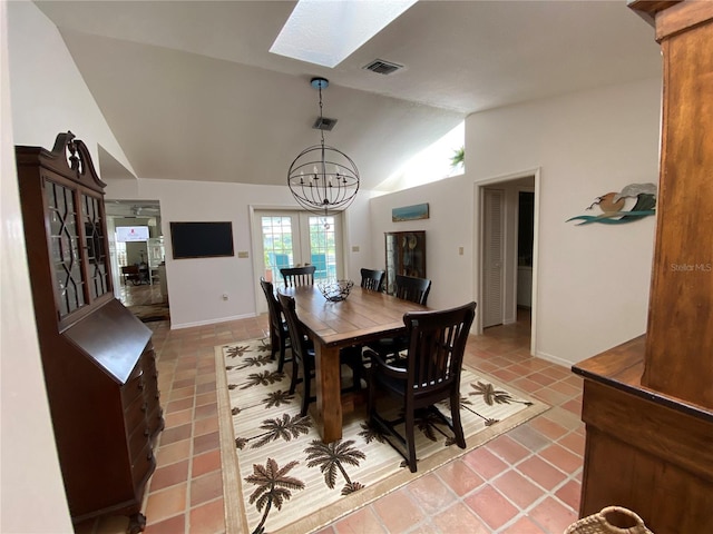 dining space with a notable chandelier, light tile flooring, and lofted ceiling with skylight