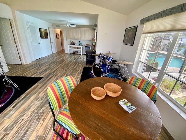 dining space with ceiling fan and wood-type flooring