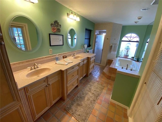 bathroom featuring tile floors, large vanity, a washtub, and dual sinks