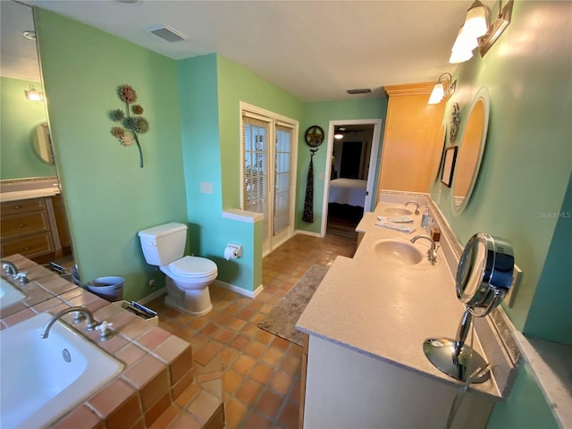 bathroom featuring tile floors, a bathing tub, toilet, and vanity