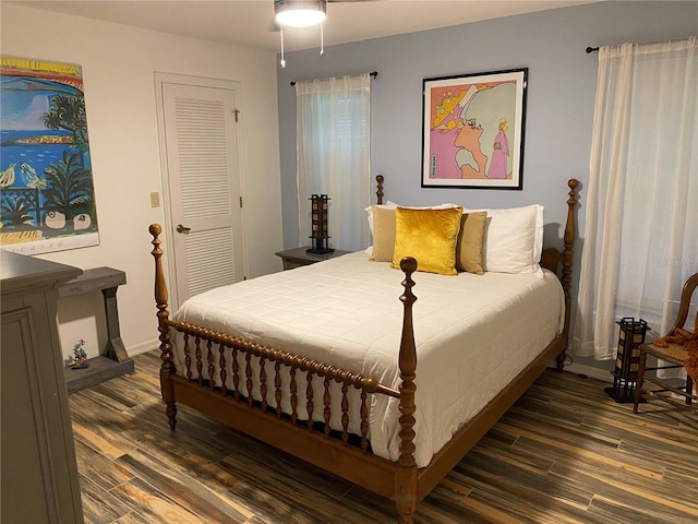 bedroom with dark wood-type flooring and a closet