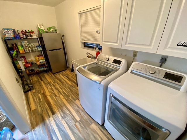 washroom with cabinets, washing machine and clothes dryer, wood-type flooring, sink, and hookup for an electric dryer