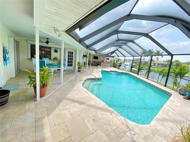 view of pool with ceiling fan, glass enclosure, and a patio