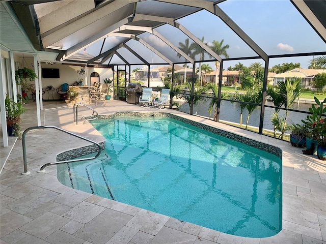 view of swimming pool with a patio, glass enclosure, and a grill