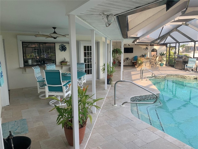 view of pool featuring glass enclosure, a patio area, and ceiling fan