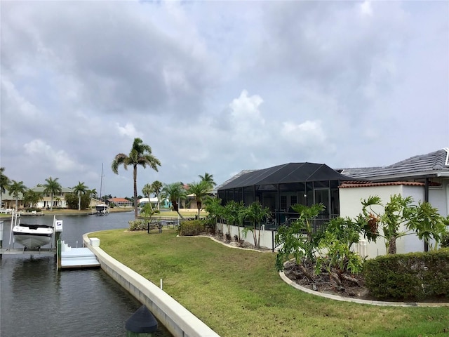 view of dock with a yard, a lanai, and a water view