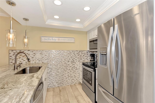 kitchen featuring pendant lighting, white cabinetry, stainless steel appliances, sink, and light stone counters