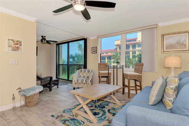 living room featuring ceiling fan, ornamental molding, and light hardwood / wood-style flooring