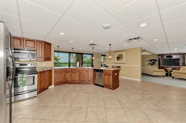 kitchen with hanging light fixtures, light tile patterned floors, kitchen peninsula, and stainless steel appliances