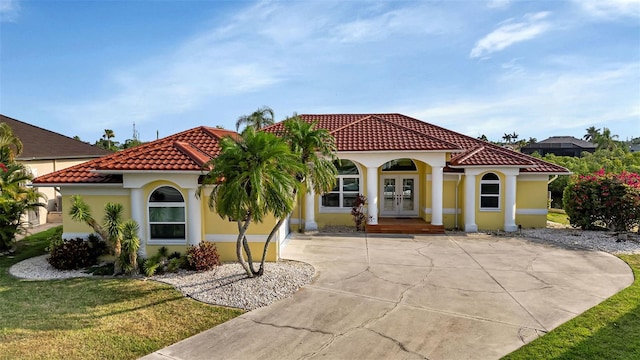 mediterranean / spanish-style home with a front lawn