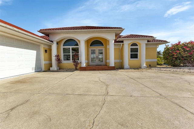 mediterranean / spanish home featuring a garage and french doors