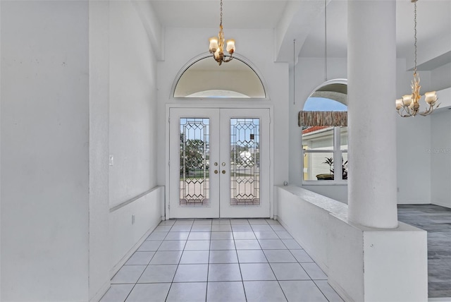 entryway featuring a chandelier, light tile flooring, and french doors