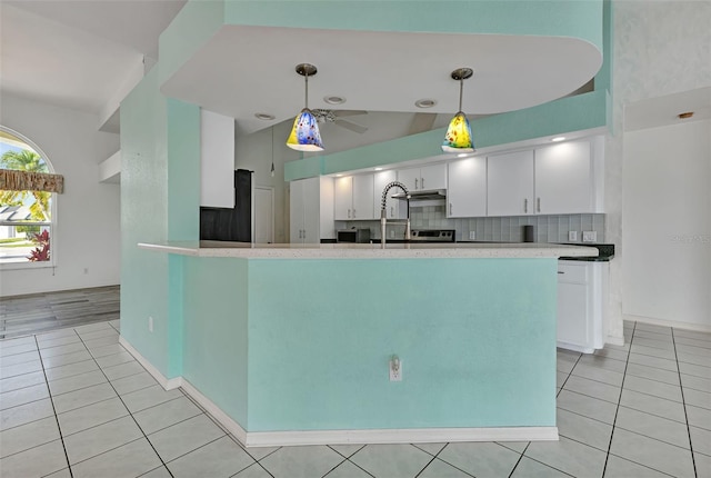 kitchen with backsplash, hanging light fixtures, ceiling fan, refrigerator, and white cabinets