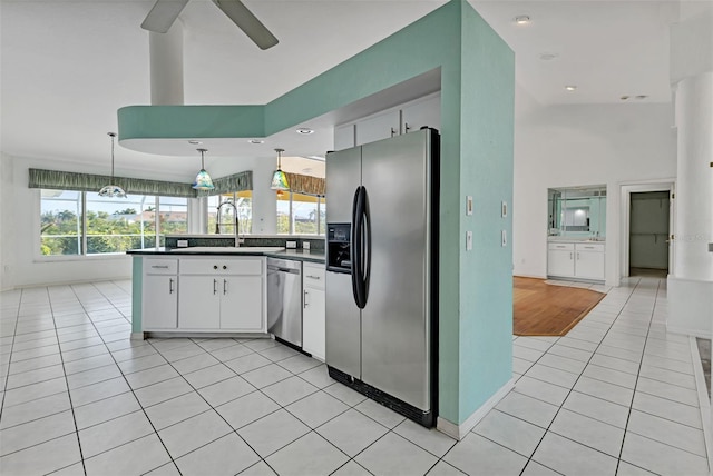 kitchen with white cabinetry, appliances with stainless steel finishes, pendant lighting, sink, and light tile floors