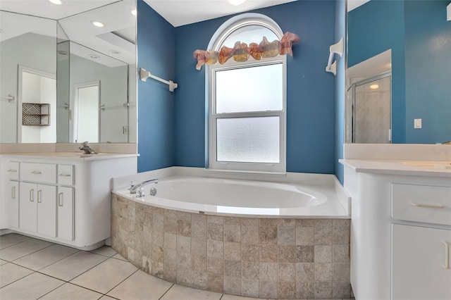 bathroom featuring tile flooring, tiled bath, and oversized vanity