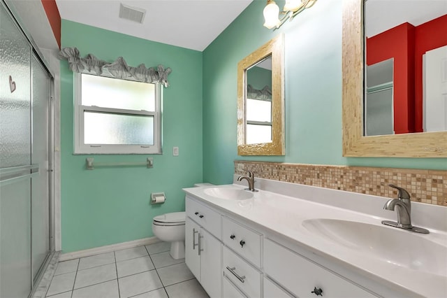 bathroom with tile floors, backsplash, large vanity, toilet, and dual sinks