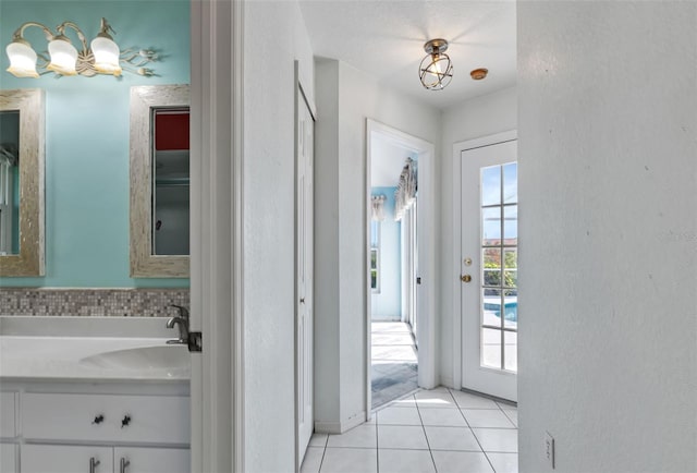 bathroom with tile floors, a notable chandelier, a textured ceiling, and large vanity