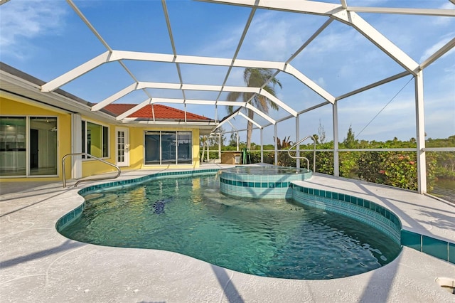 view of pool with glass enclosure, an in ground hot tub, and a patio