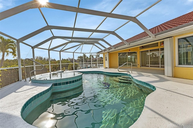 view of pool featuring ceiling fan, an in ground hot tub, glass enclosure, and a patio area