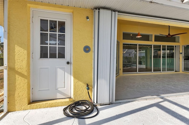 doorway to property featuring ceiling fan