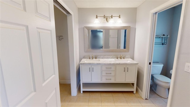 bathroom featuring tile patterned flooring, toilet, and vanity