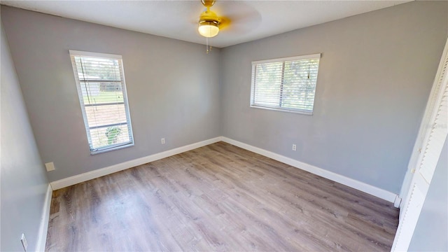 unfurnished room featuring hardwood / wood-style floors, ceiling fan, and plenty of natural light