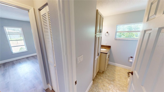 bathroom with plenty of natural light, a textured ceiling, and vanity