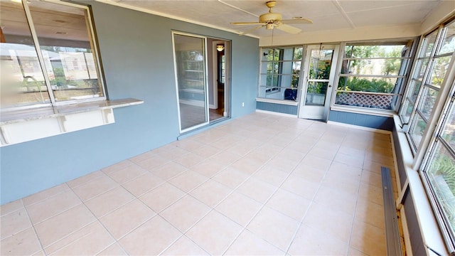 unfurnished sunroom with ceiling fan