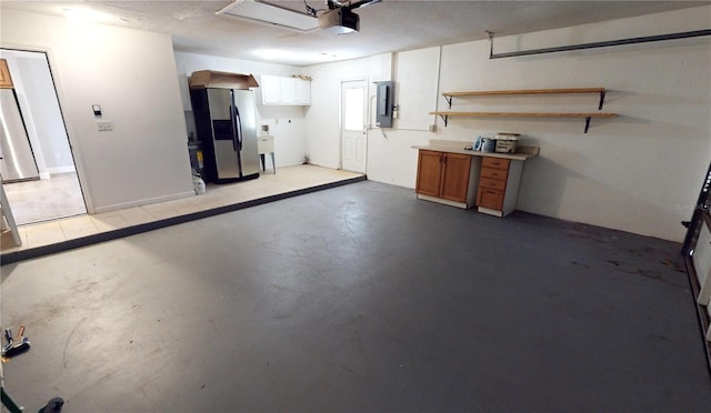 garage featuring electric panel, stainless steel fridge with ice dispenser, and stainless steel refrigerator