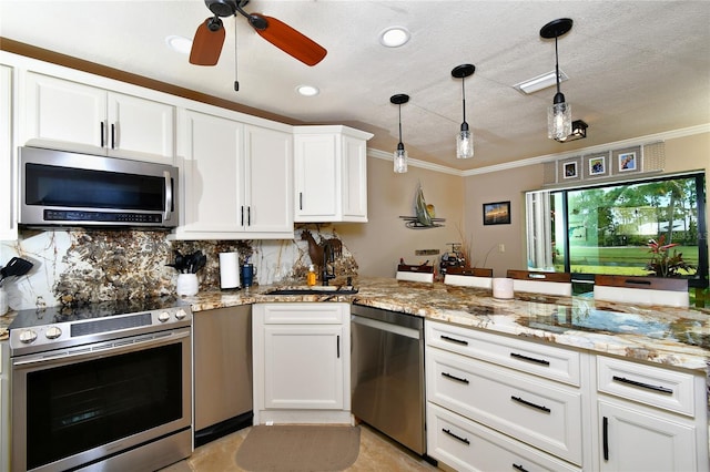 kitchen featuring stainless steel appliances, white cabinets, decorative light fixtures, sink, and tasteful backsplash