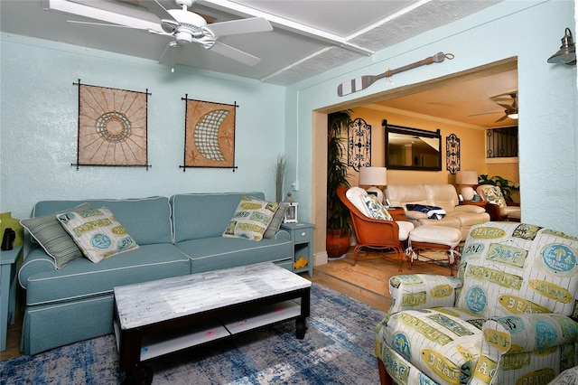 living room with ornamental molding, wood-type flooring, and ceiling fan