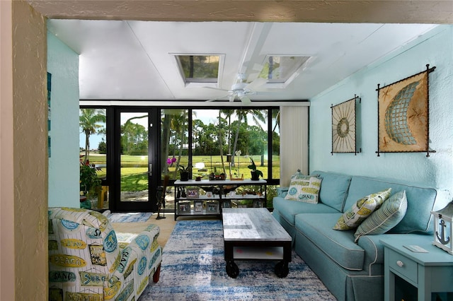 living room with floor to ceiling windows, a wealth of natural light, ceiling fan, and french doors