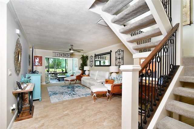 living room featuring tile flooring, ceiling fan, a textured ceiling, and ornamental molding