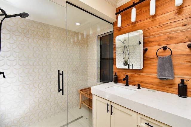 bathroom with a shower with door, wooden walls, and vanity with extensive cabinet space