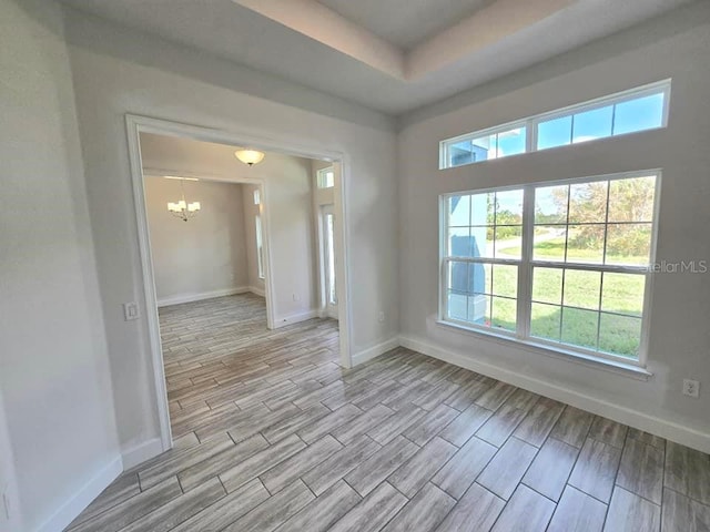 unfurnished room featuring light wood-type flooring and a chandelier