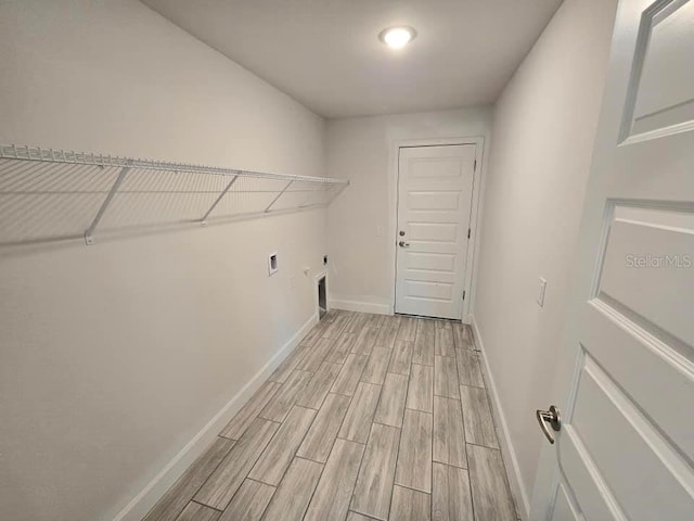 clothes washing area with electric dryer hookup and light hardwood / wood-style flooring