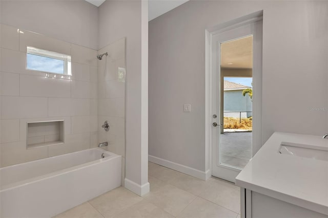 bathroom with tiled shower / bath combo, tile patterned flooring, and vanity